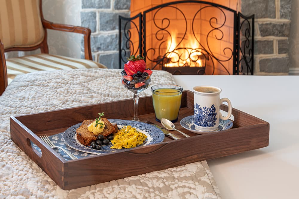 Tray of gourmet breakfast with berries, fresh orange juice, and coffee in a B&B Guest Room