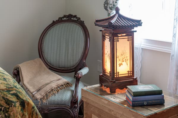 An antique wooden lantern and chair in the sitting area of The Brookside Room at our Hershey bed and breakfast
